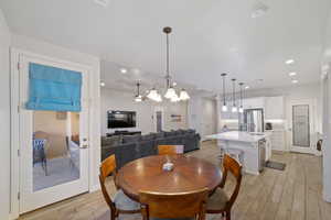Dining area featuring light wood-style flooring, a chandelier, a ceiling fan, and recessed lighting