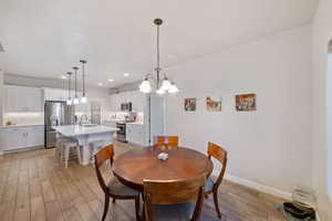 Dining space with light wood finished floors, baseboards, recessed lighting, and a chandelier