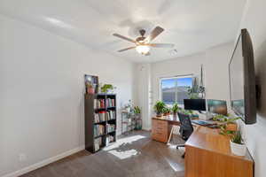Office area with light colored carpet, ceiling fan, and baseboards