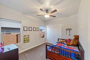 Carpeted bedroom with baseboards, a ceiling fan, and a closet