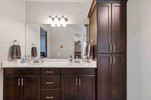 Full bathroom with double vanity and a closet