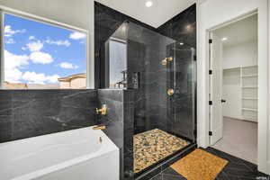 Bathroom featuring a garden tub, a stall shower, a walk in closet, recessed lighting, and tile patterned floors