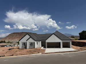 Ranch-style house featuring a mountain view, stucco siding, a garage, and concrete driveway
