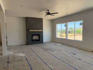 Unfurnished living room with a ceiling fan, a premium fireplace, and recessed lighting
