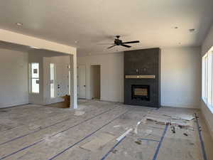 Unfurnished living room featuring a high end fireplace, a textured ceiling, ceiling fan, and recessed lighting