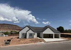 View of front of home featuring stucco siding, driveway, a mountain view, and an attached garage
