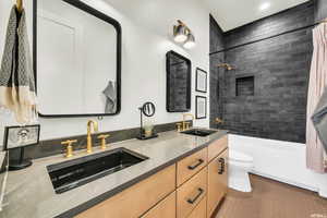 Full bathroom featuring toilet, double vanity, shower / bathtub combination with curtain, and recessed lighting