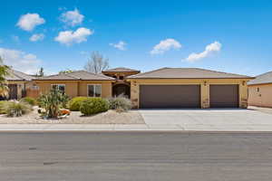Prairie-style home featuring a garage, stone siding, driveway, and stucco siding