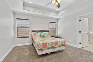 Bedroom with carpet flooring, multiple windows, and baseboards