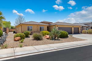 View of front of home featuring a garage, stucco siding, concrete driveway, and a tile roof