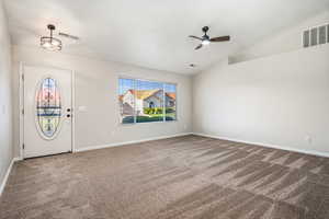 Entryway with carpet floors, a ceiling fan, lofted ceiling, and baseboards