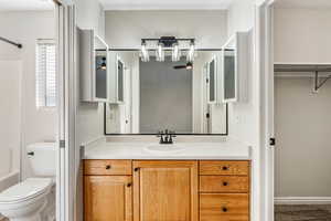 Bathroom featuring vanity, toilet, bathtub / shower combination, and baseboards