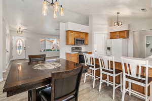 Dining room with lofted ceiling, baseboards, and a chandelier