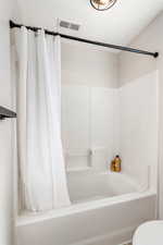 Full bathroom with shower / bath combo with shower curtain and toilet