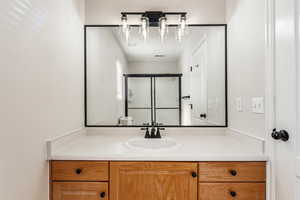 Bathroom featuring vanity and a shower with shower door