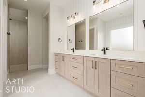 Full bath featuring double vanity, walk in shower, and baseboards