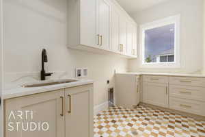 Laundry room with cabinet space, hookup for a washing machine, hookup for an electric dryer, and baseboards