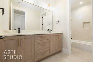 Bathroom with double vanity, tile patterned flooring, baseboards, shower / washtub combination, and toilet