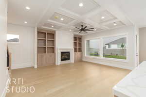 Unfurnished living room featuring light wood-style floors, coffered ceiling, beam ceiling, a glass covered fireplace, and recessed lighting