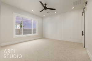 Carpeted empty room with recessed lighting, a ceiling fan, a barn door, and baseboards