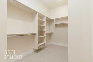 Walk in closet featuring light colored carpet