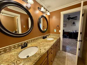 Full bathroom with tile patterned floors, double vanity, ceiling fan, and crown molding