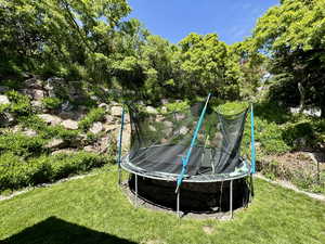 View of green lawn featuring a trampoline