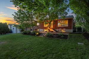 Back of property at dusk with brick siding and a patio area