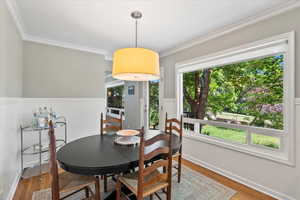 Dining room featuring wood finished floors and ornamental molding