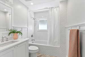 Full bath featuring tiled shower / bath, vanity, and toilet