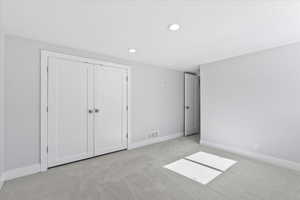 Unfurnished bedroom with carpet flooring, recessed lighting, baseboards, and a closet