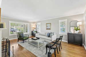 Living room with ornamental molding, wood finished floors, and baseboards