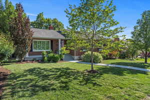 View of front of house featuring a front lawn and brick siding