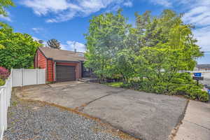 View of front of house with a gate, asphalt driveway, a shingled roof, and an attached garage