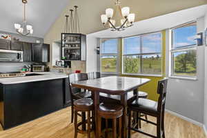 Dining room featuring a chandelier, light wood-style flooring, and baseboards