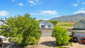 Obstructed view of property featuring driveway, a garage, and a mountain view