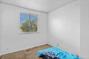 Unfurnished bedroom featuring carpet flooring, baseboards, and a textured ceiling