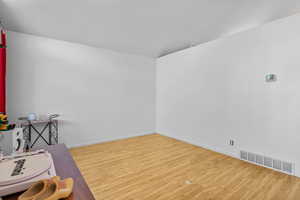 Unfurnished room with wood finished floors and baseboards