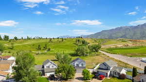 Aerial perspective of suburban area featuring a mountainous background and a golf club