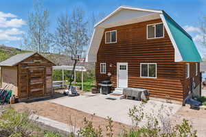Rear view of house featuring a gambrel roof, entry steps, and a patio