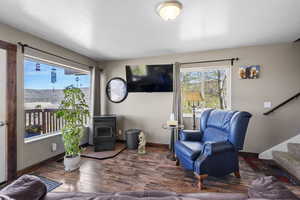 Living room with stairs, wood finished floors, plenty of natural light, and baseboards