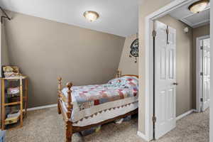 Carpeted bedroom featuring baseboards and attic access