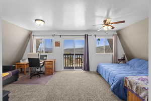 Carpeted bedroom with access to exterior, an office area, baseboards, and a ceiling fan