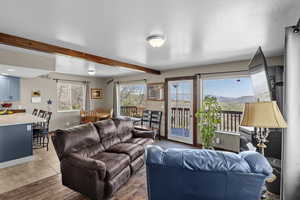 Living area featuring beam ceiling and light wood-style floors