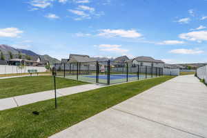 View of community featuring a residential view, a tennis court, a mountain view, and a gate