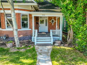 Property entrance with brick siding and covered porch