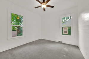 Empty room with carpet flooring, a ceiling fan, and baseboards