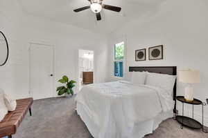 Carpeted bedroom featuring a ceiling fan and ensuite bathroom