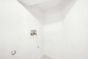 Laundry area with electric dryer hookup, hookup for a washing machine, and baseboards