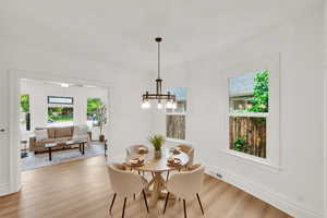 Dining area with light wood-style flooring, baseboards, and a chandelier